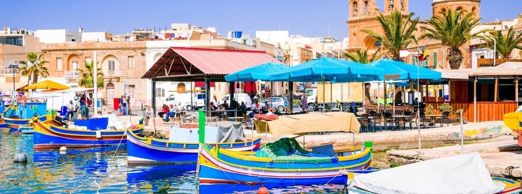 Malta. Traditional eyed colorful boats Luzzu in the Harbor of fishing village Marsaxlokk, Mediterranean Sea.